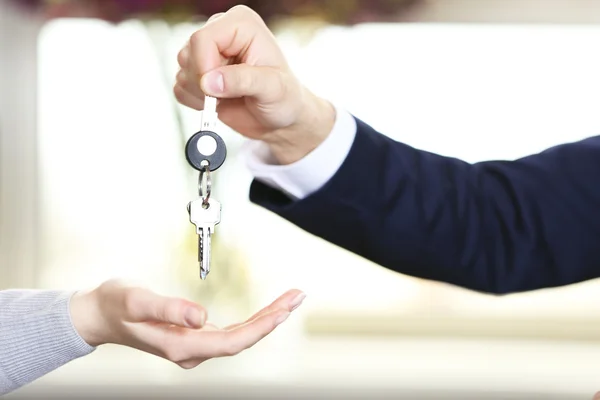 Hand of businessman giving keys to female hand — Stock Photo, Image