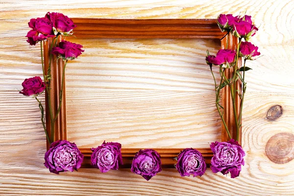 Fotorahmen mit getrockneten Blumen auf Holzgrund — Stockfoto