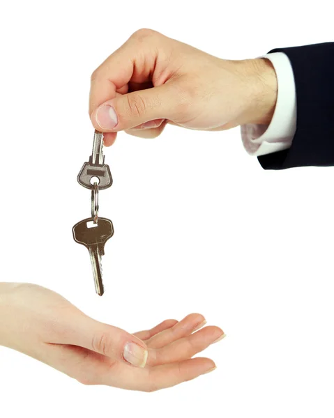 Male hand giving key with trinket to female hand isolated on white Stock Image