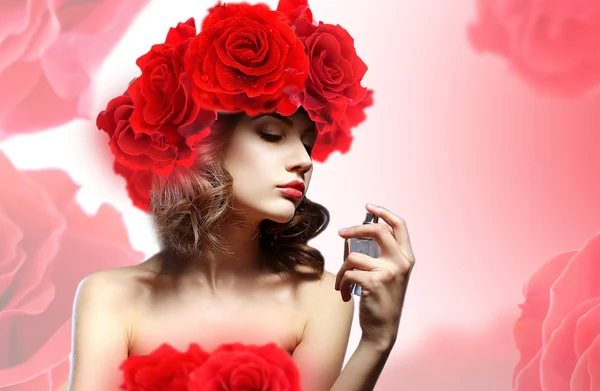 Hermosa mujer con frasco de perfume en flores — Foto de Stock