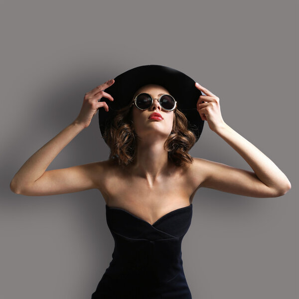 молодая модель в шляпе и солнечных очках
