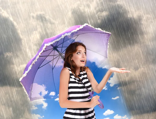 Девушка с зонтиком стоит под дождем — стоковое фото