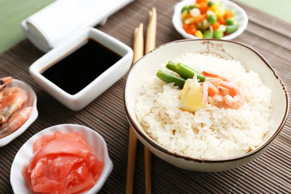 Boiled rice with shrimps and vegetables on bamboo mat background — Stock Photo, Image