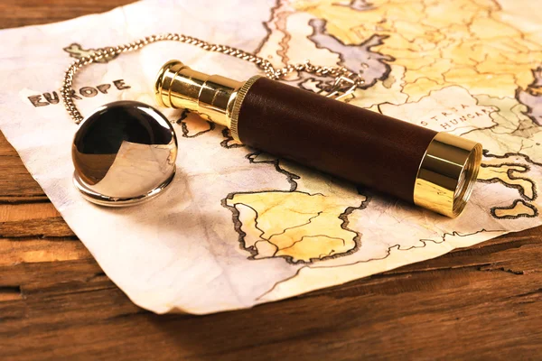 Spyglass, zakhorloge en wereld kaart op houten tafel achtergrond — Stockfoto