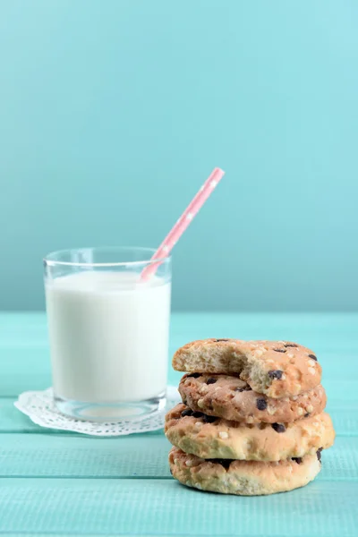 Вкусное печенье и стакан молока на фоне цвета дерева — стоковое фото