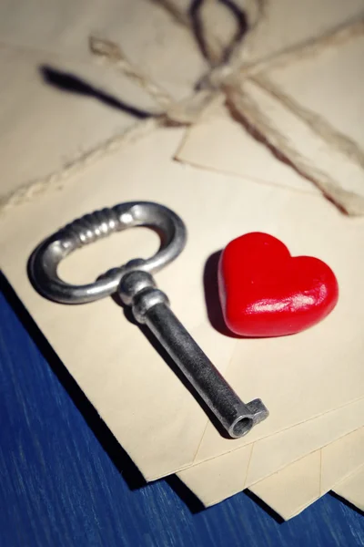 Chave com coração vermelho em letras e cor de fundo de mesa de madeira — Fotografia de Stock