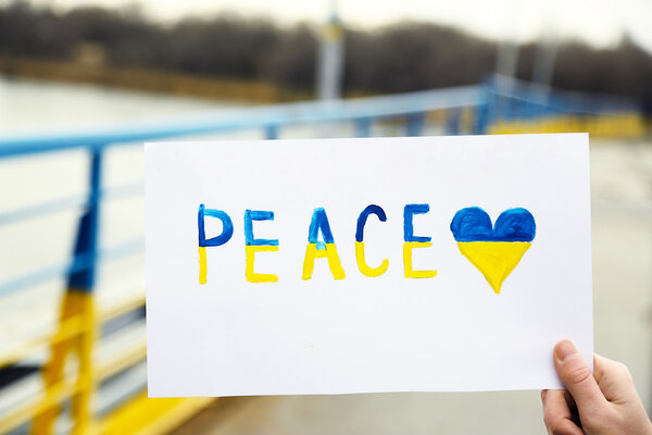 Hand holding paper with Peace of Ukraine