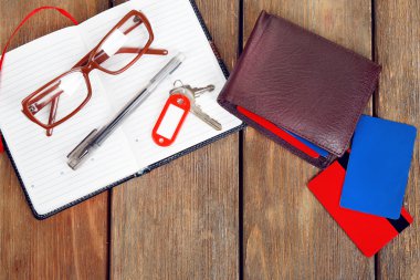 Açık defter, kalem, anahtar, gözlük ve ahşap masa arka plan üzerinde cüzdan