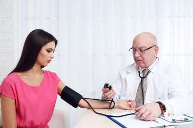 Profesyonel doktor ofisinde beyaz perde arka plan üzerinde kan basıncı ölçme