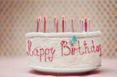 Birthday cake with candles on colorful dots background clipart