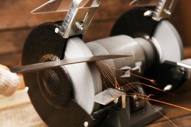 Bıçak Bileyici ve ahşap masa, closeup üzerinde bıçak el