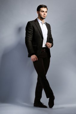 gri arka plan üzerinde takım elbiseli şık adam