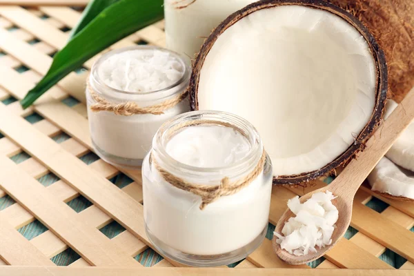 Fresh coconut oil in glassware on wooden grid background — Stock Photo, Image