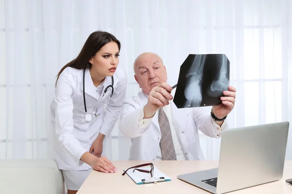 Los médicos que reciben resultados de rayos X en la oficina sobre fondo blanco — Foto de Stock