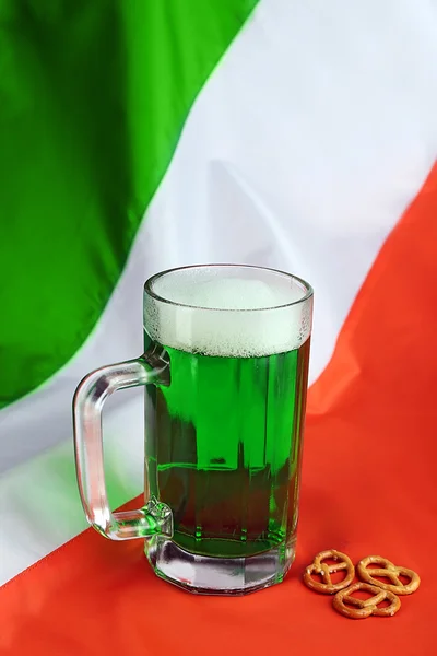 Glass of green beer on Ireland flag background — Stock Photo, Image