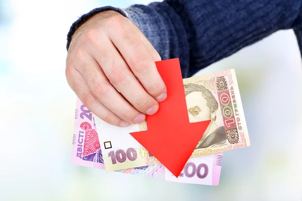 Muž drží peníze a červená šipka zblízka — Stock fotografie