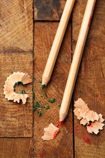 Buntstifte aus Holz mit Spitzspänen auf Holztisch — Stockfoto