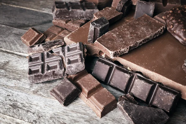 Uppsättning av choklad på träbord, närbild — Stockfoto