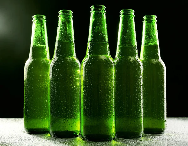 Стеклянные бутылки пива на тёмном фоне — стоковое фото