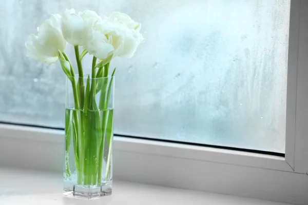 Hermosos tulipanes blancos en jarrón de vidrio sobre fondo alféizar de ventana — Foto de Stock