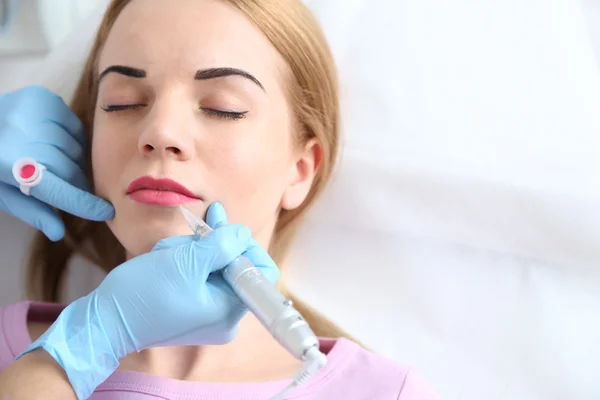 Cosmetólogo aplicando maquillaje permanente en los labios — Foto de Stock