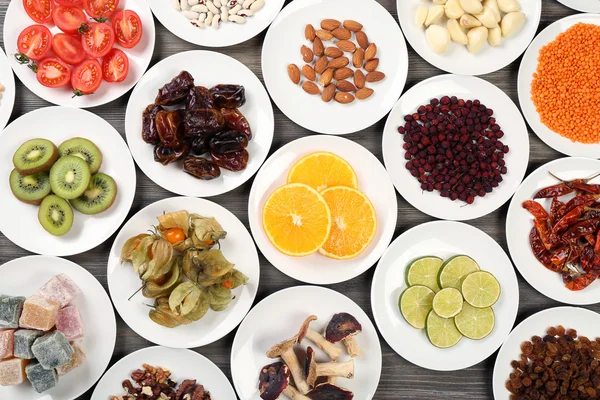 Different products on saucers on wooden table, top view — Stock Photo, Image