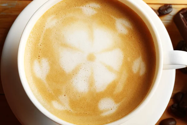 Taza de café con leche arte en la mesa de madera, primer plano — Foto de Stock