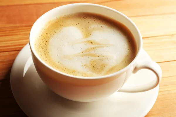 Kopp kaffe latte art på träbord, närbild — Stockfoto