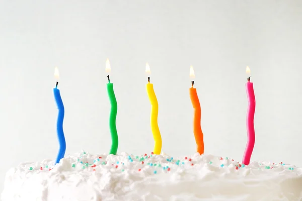 Renkli arkaplanda mumlar olan doğum günü pastası — Stok fotoğraf