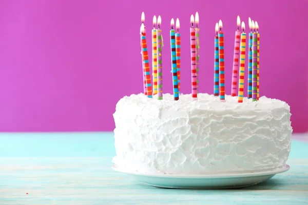 Birthday cake with candles on color background