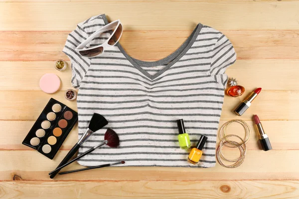 Kvinnlig skjorta och kosmetika på träbord, ovanifrån — Stockfoto