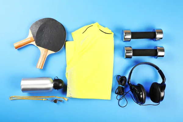 Sportuitrusting en t-shirt op kleurentabel, bovenaanzicht — Stockfoto