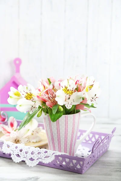 Krásné květiny v poháru, na dřevěné pozadí — Stock fotografie