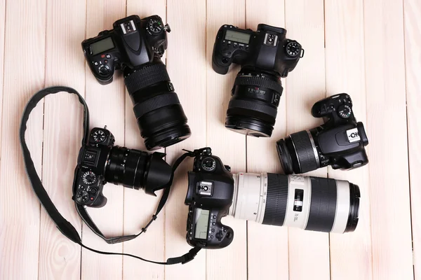 Modern cameras on wooden table, top view — Stock Photo, Image