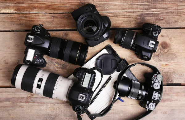 Still life with modern cameras on wooden table, top view — Stock Photo, Image