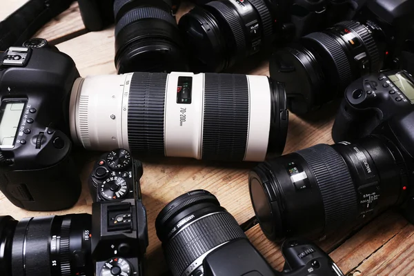 Modern cameras on wooden table, closeup — Stock Photo, Image