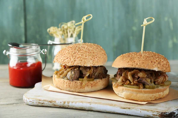 Gustoso panino sul tagliere, su sfondo di legno a colori. Concetto di cibo malsano — Foto Stock