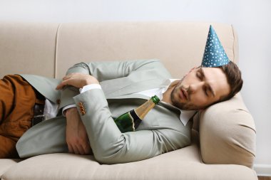 Genç adam eğlenceli kapattıktan sonra kanepede