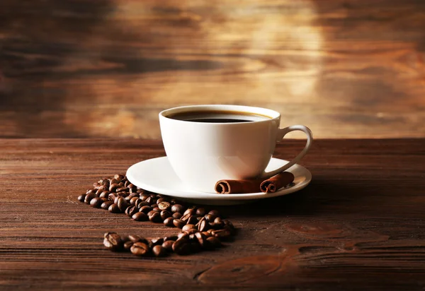 Φλιτζάνι καφέ με κόκκους σε ξύλινα φόντο — Φωτογραφία Αρχείου