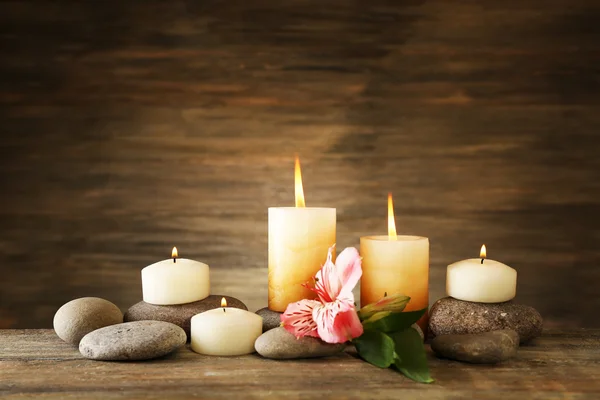 Beautiful composition with candles and spa stones on wooden background — Stock Photo, Image