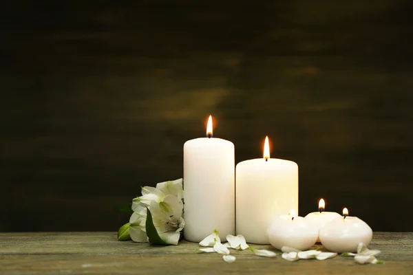 Velas com flores no fundo de madeira — Fotografia de Stock