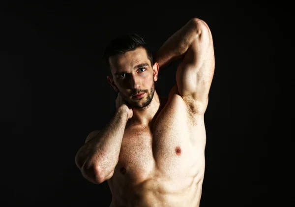 Muscle young man on black background — Stock Photo, Image