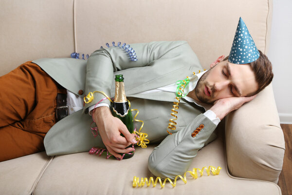 Молодой человек на диване после веселого закрытия
