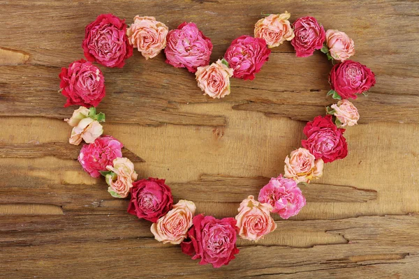 Heart of beautiful dry flowers on wooden background — Stock Photo, Image