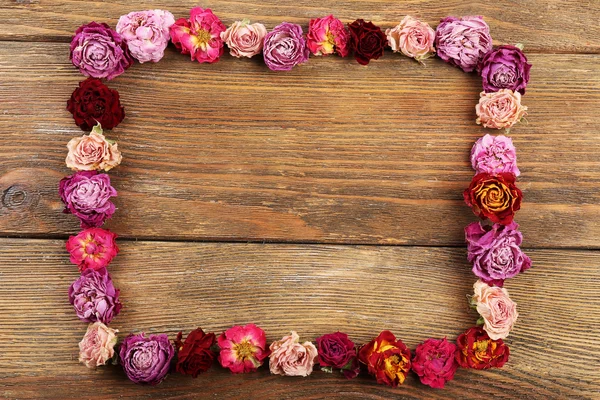 Getrocknete Rosen als Rahmen auf Holzgrund — Stockfoto