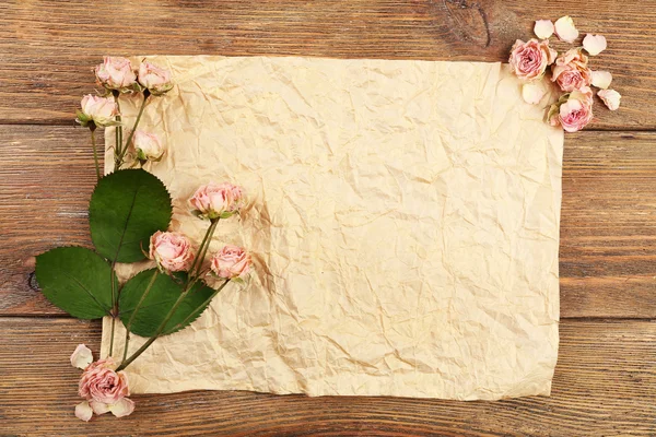 Dried roses on sheet of paper — Stock Photo, Image