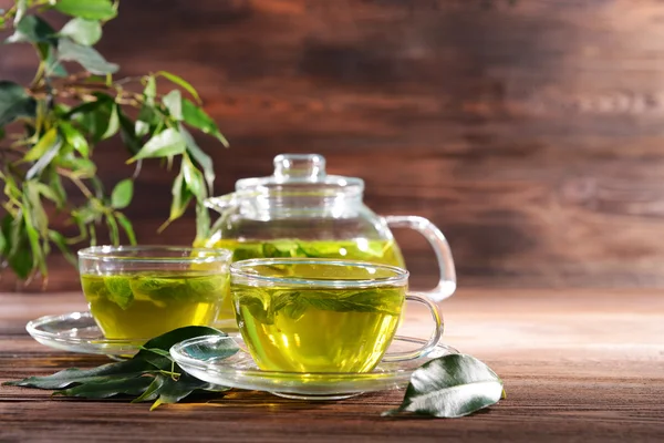 Cups of green tea on table on wooden background — Stock Photo, Image