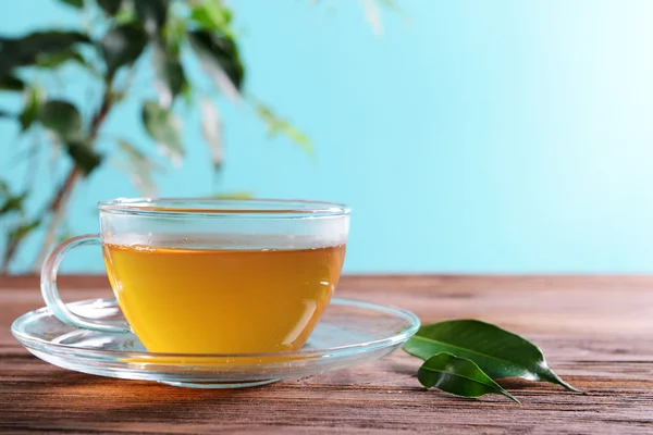 Tazza di tè verde sul tavolo su sfondo verde — Foto Stock