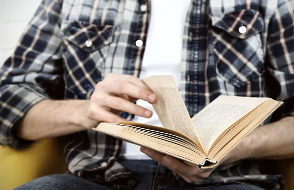 Jonge man lezen boek, close-up, op lichte achtergrond — Stockfoto