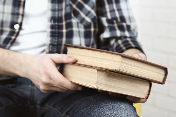 Ung man läser bok, närbild, på ljus bakgrund — Stockfoto